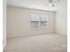 Serene bedroom showcasing two large windows, neutral carpet, and a ceiling fan at 616 Smokehouse Ln, Albemarle, NC 28001