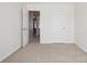 A neutral bedroom features an open doorway and white closet door at 616 Smokehouse Ln, Albemarle, NC 28001