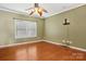 Bright bedroom with hardwood floors, a ceiling fan, and a large window providing natural light at 616 Smokehouse Ln, Albemarle, NC 28001