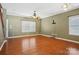 Spacious living room featuring gleaming hardwood floors, natural light, and a ceiling fan for comfortable living at 616 Smokehouse Ln, Albemarle, NC 28001