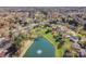 Aerial shot capturing a suburban neighborhood with mature trees, a serene pond, and various home styles at 6720 Neuhoff Ln, Charlotte, NC 28269