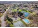 The aerial view shows tennis courts, a pool, a pond, and a clubhouse in this community surrounded by mature trees at 6720 Neuhoff Ln, Charlotte, NC 28269