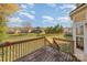 A view from the home's wooden back deck shows a large grassy backyard with a wood fence and mature trees in the distance at 6720 Neuhoff Ln, Charlotte, NC 28269