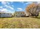 A large, open backyard with lush green grass and flowering clover, partially enclosed by a rustic split rail fence at 6720 Neuhoff Ln, Charlotte, NC 28269