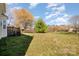 Spacious backyard features a grassy lawn, mature trees, and a wooden fence at 6720 Neuhoff Ln, Charlotte, NC 28269