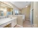 Bright bathroom features a double vanity, soaking tub, tiled floors, and separate shower at 6720 Neuhoff Ln, Charlotte, NC 28269