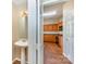 Half bathroom with pedestal sink adjacent to kitchen featuring dark granite countertops and wood cabinets at 6720 Neuhoff Ln, Charlotte, NC 28269