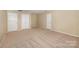 Neutral bedroom with 3 white doors and neutral carpet at 6720 Neuhoff Ln, Charlotte, NC 28269