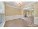 Bright dining room with chandelier, decorative molding, and an open view of the living room at 6720 Neuhoff Ln, Charlotte, NC 28269