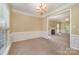 Open-concept dining room with chandelier, decorative molding, and view into the living room at 6720 Neuhoff Ln, Charlotte, NC 28269