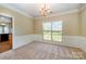 Elegant dining room with chandelier lighting, wainscoting, and neutral carpeting at 6720 Neuhoff Ln, Charlotte, NC 28269