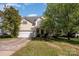 Two-story home with attached garage, covered front porch, and tidy front lawn at 6720 Neuhoff Ln, Charlotte, NC 28269