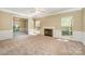 Bright living room featuring a fireplace, neutral carpet, and abundant natural light at 6720 Neuhoff Ln, Charlotte, NC 28269