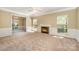 Open-concept living room with fireplace, neutral carpet, and abundant natural light at 6720 Neuhoff Ln, Charlotte, NC 28269