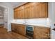 Custom bar area features wooden cabinets, marble countertops, a wine cooler, and under-cabinet lighting at 810 Martingale Ln, Davidson, NC 28036