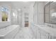 Luxurious bathroom featuring marble floors, a freestanding tub, glass shower, and dual vanities at 810 Martingale Ln, Davidson, NC 28036