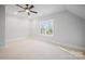 Bright bedroom with neutral colors and carpet, illuminated by natural light, featuring a ceiling fan at 810 Martingale Ln, Davidson, NC 28036