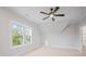 Attic bedroom featuring a large window and neutral carpet, with an angled ceiling and ceiling fan at 810 Martingale Ln, Davidson, NC 28036