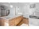 A modern kitchen featuring a large island with a marble countertop, wooden cabinetry, and stainless steel appliances at 810 Martingale Ln, Davidson, NC 28036