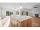 A spacious kitchen island with a marble countertop and wooden cabinets offers views of the living area and backyard at 810 Martingale Ln, Davidson, NC 28036