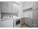 Well-equipped laundry room with modern washer and dryer, ample cabinet space, and marble countertop at 810 Martingale Ln, Davidson, NC 28036