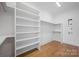 Walk-in closet featuring custom shelves and wood flooring at 810 Martingale Ln, Davidson, NC 28036