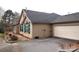 View of the home's exterior showing stone and siding details plus the two car garage at 810 Wynnshire Dr # D, Hickory, NC 28601