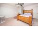 Bedroom featuring carpeted floors, ceiling fan, and a large bed with wooden frame at 9131 Strattonville Ct, Huntersville, NC 28078