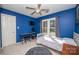 Bedroom with a large window, ceiling fan, desk, and blue accent wall at 9131 Strattonville Ct, Huntersville, NC 28078