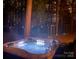 Outdoor hot tub with integrated lights, set in a private wooded backyard at night at 9131 Strattonville Ct, Huntersville, NC 28078