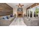 Warm living room featuring a brick fireplace, wood paneling, and comfortable seating arrangement at 9131 Strattonville Ct, Huntersville, NC 28078