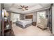 Spacious bedroom with tray ceilings, natural light and a sliding barn door to the bathroom at 9131 Strattonville Ct, Huntersville, NC 28078