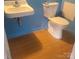 Bathroom includes a toilet and sink with blue walls and wood look flooring at 1033 College Ave, Shelby, NC 28152