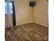 Well-lit bedroom featuring wood flooring, and a window with blinds and curtains at 1033 College Ave, Shelby, NC 28152