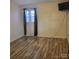 This bedroom features wood flooring, window with blinds and dark curtains and mounted TV at 1033 College Ave, Shelby, NC 28152