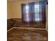 Empty bedroom showcasing the natural light, neutral color palette, and wood-look baseboards at 1033 College Ave, Shelby, NC 28152