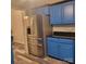 Modern kitchen with stainless steel refrigerator and stylish blue cabinets with black countertops at 1033 College Ave, Shelby, NC 28152