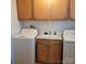 Functional laundry room with washer, dryer, utility sink, and wood cabinets at 1033 College Ave, Shelby, NC 28152