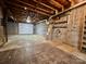 Unfinished basement featuring concrete flooring, cinderblock walls, and white garage door at 1168 Mcclain Rd, Hiddenite, NC 28636