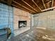 Unfinished basement showing a brick fireplace, cinderblock walls, and concrete flooring at 1168 Mcclain Rd, Hiddenite, NC 28636