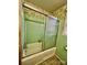 A vintage bathroom with green tile, a shower-tub combination, and patterned wallpaper at 1168 Mcclain Rd, Hiddenite, NC 28636