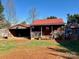 Exterior of the cabin and garage featuring red roofs, a wooden porch, a well, and lush greenery at 1168 Mcclain Rd, Hiddenite, NC 28636