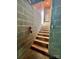 A stairway with concrete block walls leads upwards toward a doorway with a visible exit to the outside at 1168 Mcclain Rd, Hiddenite, NC 28636