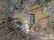 Aerial view showcasing the home's roof, backyard, storage shed, and driveway amid natural surroundings at 1200 Carey Ct, Charlotte, NC 28210