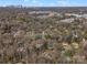 Aerial view shows houses nestled among trees in a suburban landscape, with cityscape in the background at 1200 Carey Ct, Charlotte, NC 28210