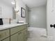 Bathroom with a tub, tiled walls, a vanity with a sink, and a patterned floor at 1200 Carey Ct, Charlotte, NC 28210