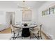 Dining area with round table, modern chairs, and decorative lighting fixture and adjacent to living area at 1200 Carey Ct, Charlotte, NC 28210