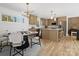 Open-concept dining area with modern lighting fixture, seating, and view of the updated kitchen at 1200 Carey Ct, Charlotte, NC 28210