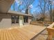 Wide wood deck featuring stylish gray brickwork on the home's exterior and a picturesque wooded area at 1200 Carey Ct, Charlotte, NC 28210