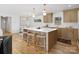 This modern kitchen features an island with seating, stainless steel appliances and hardwood floors at 1200 Carey Ct, Charlotte, NC 28210